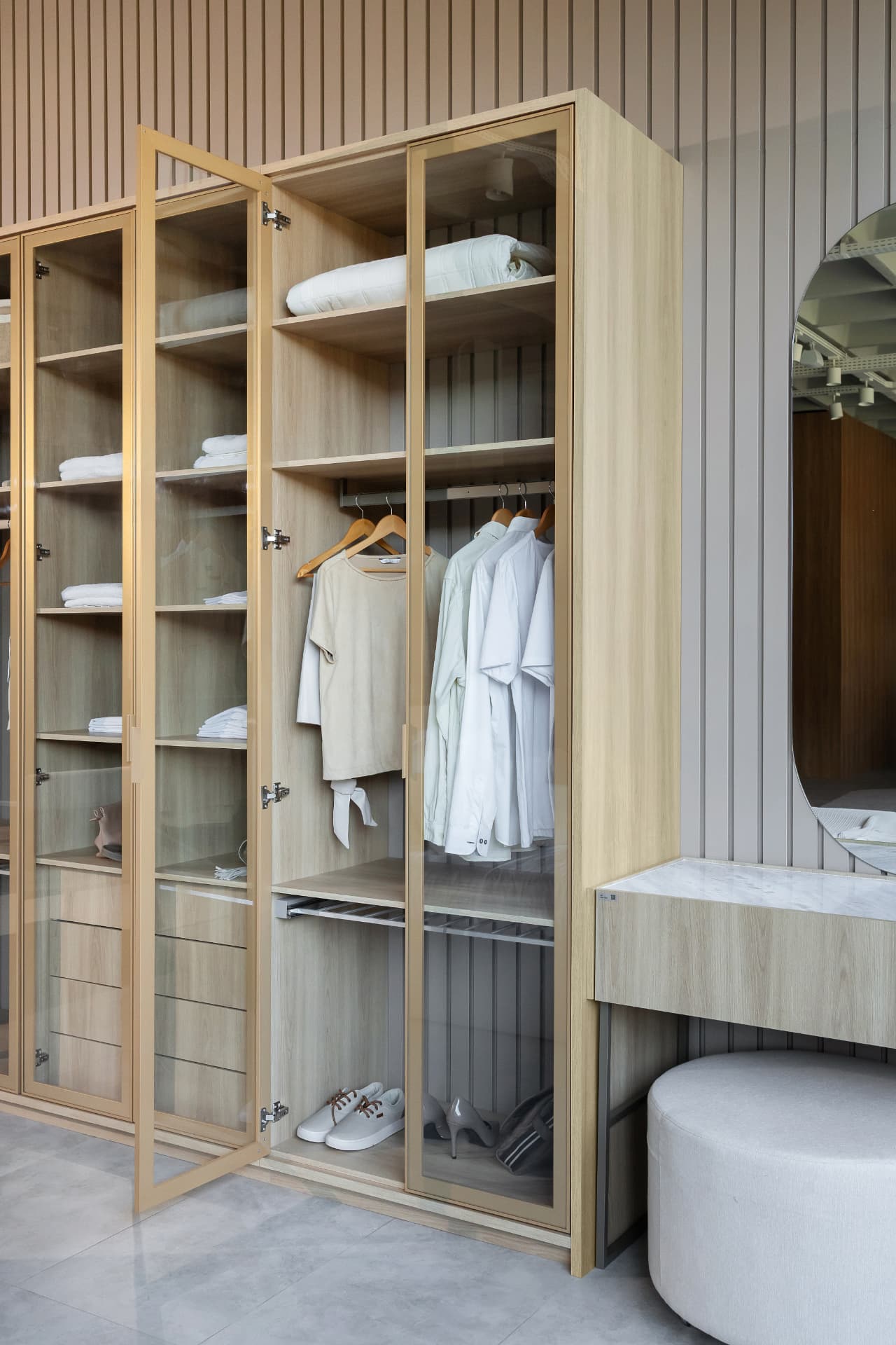 Closet planejado com portas de vidro e iluminação interna